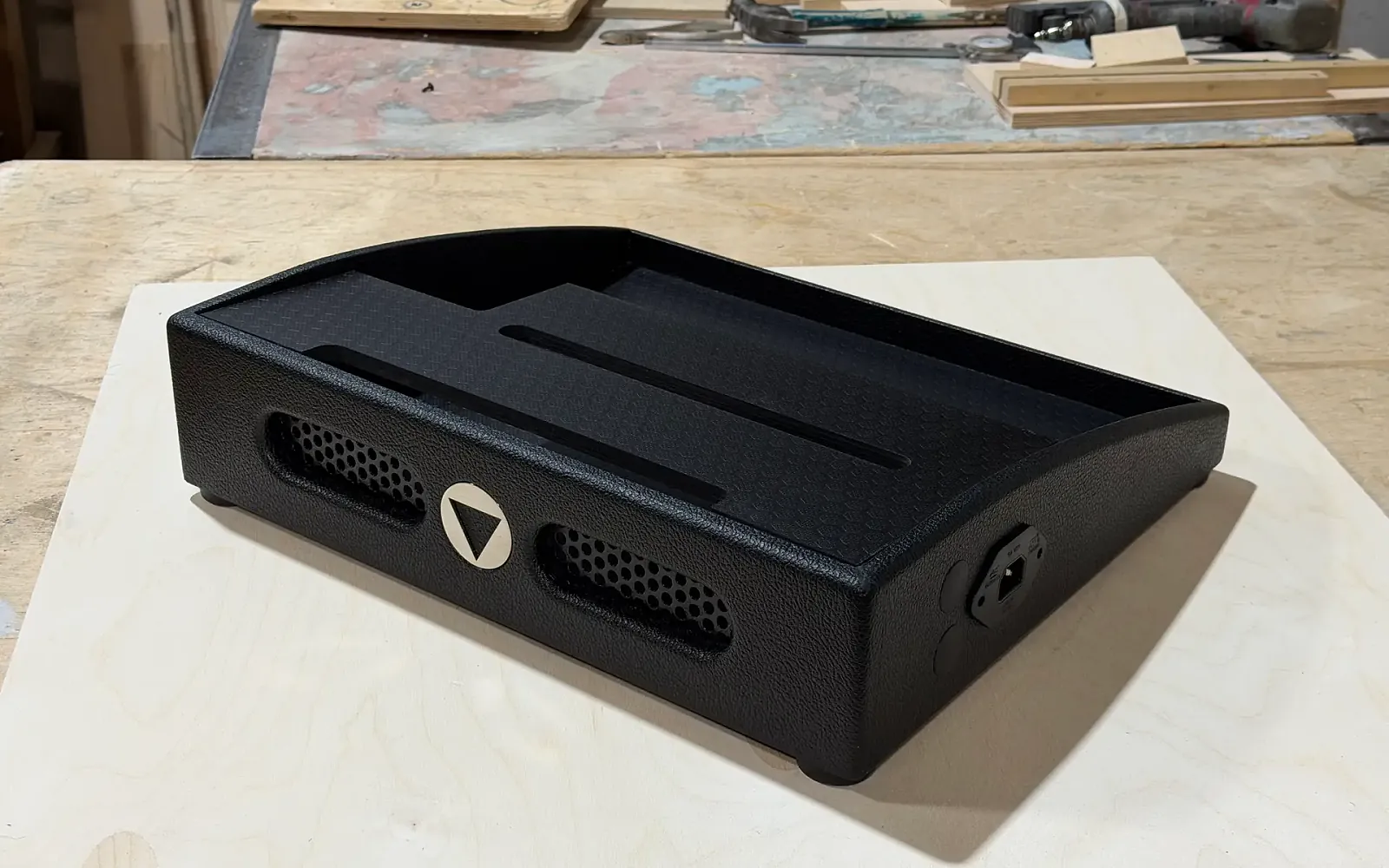 Handmade black two-deck guitar pedalboard in the builder's workshop